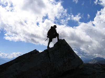 silhouette of man stepping on rock formation at daytime thumbnail