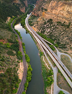 river near brown valley with trees and road thumbnail