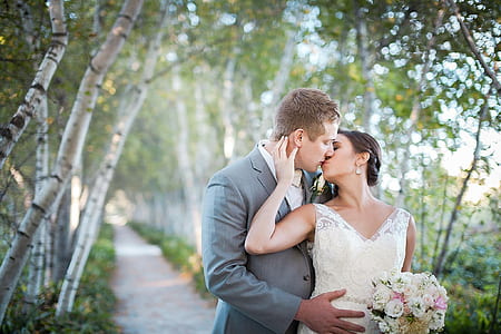 man kissing woman wearing white wedding dress thumbnail