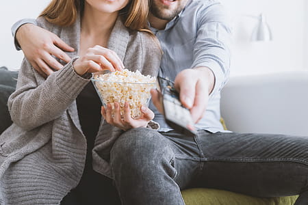 Happy young couple relaxing and watching TV at home thumbnail