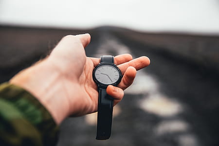 Watch Held In Hand Over Road Photo thumbnail