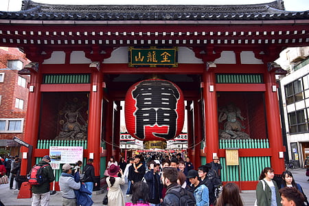 people walking under the red and white chinese temple gate at daytime thumbnail
