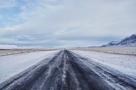 grey road near glacier mountains under blue sky thumbnail
