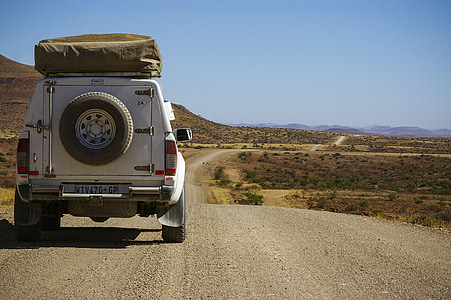 white SUV on grey dirt road during daytime thumbnail