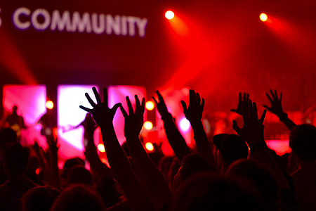 people raising hands in room with red spotlights thumbnail