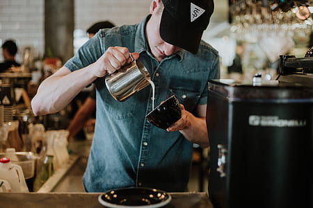 man putting milk on black ceramic teacup thumbnail