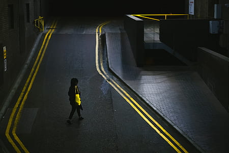 person walking towards building during nighttime thumbnail