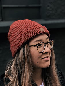 close-up photography of woman wearing red knit cap and eyeglasses thumbnail