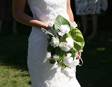 woman wearing white floral wedding dress holding white flowers thumbnail