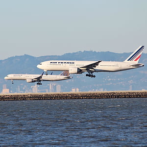 Air France airliner flying beside another airliner above water at daytime thumbnail