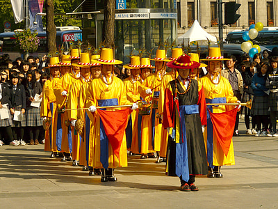 people in yellow suit lining up while walking on road thumbnail