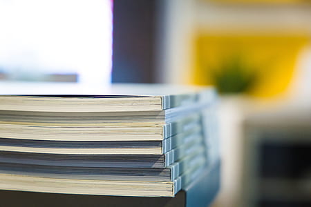 selective focus photo of pile of books inside room thumbnail