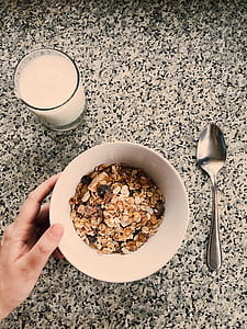 Round White Ceramic Bowl Filled With Oatmeal Beside Glass Of Milk thumbnail
