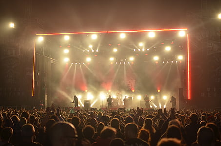 people performing on stage under red and orange track lights thumbnail