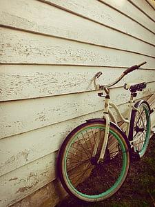 white cruiser bicycle parked beside wooden wall thumbnail