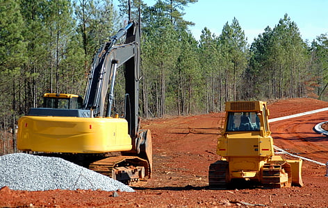 yellow excavator on dirt road thumbnail