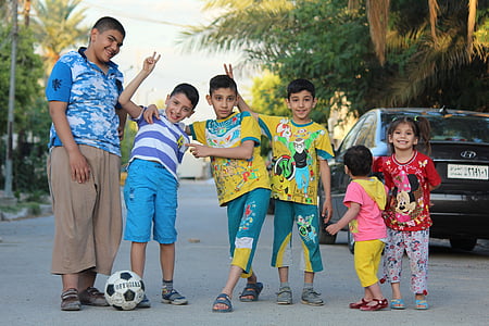 children standing on road near black Hyundai sedan at daytime thumbnail