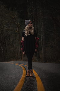 shallow focus photography of woman standing on forest pathway thumbnail