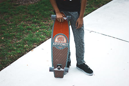 man standing holding Kryptonics skateboard thumbnail