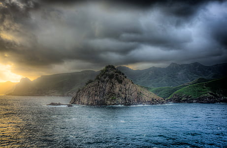 body of water and brown rock mountain thumbnail