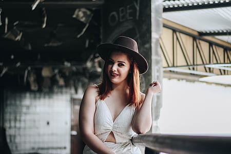 woman in white shirt wearing brown fedora hat thumbnail