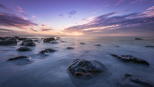 timelapse photography of body of water with boulders during golden hour thumbnail