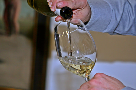 person pouring white wine in clear wine glass thumbnail