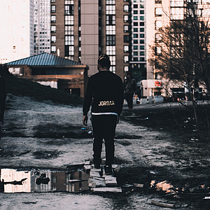 photo of man standing on gray brick bridge thumbnail