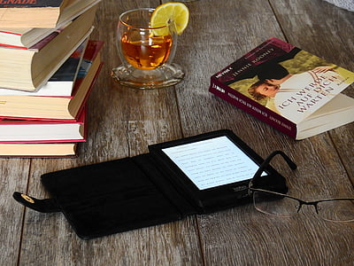 black e-book reader beside eyeglasses thumbnail