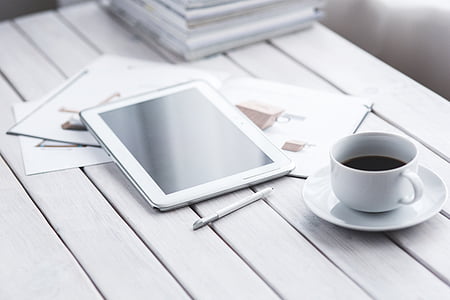 white tablet computer beside white ceramic teacup thumbnail