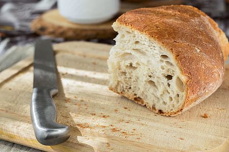 Sliced Bread and Stainless Steel Knife on Top of Brown Wooden Chopping Board thumbnail