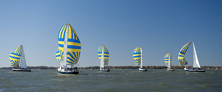 blue-and-yellow sailboats on body of water thumbnail