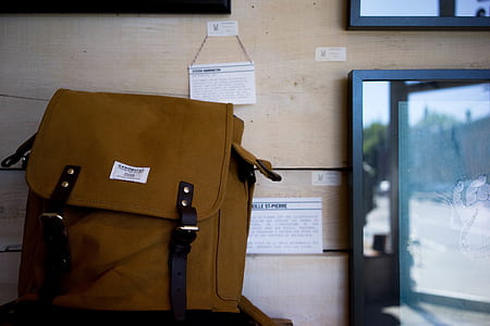 brown leather rucksack bag near brown wooden wall thumbnail