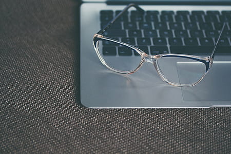 clear framed eyeglasses on silver MacBook thumbnail