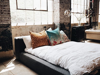 brown and teal throw pillow on top of white mattress thumbnail