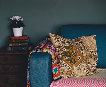 brown and orange throw pillow on top of teal velvet sofa thumbnail