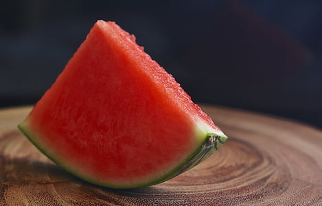 tilt shift lens photography of sliced watermelon on brown wooden table thumbnail