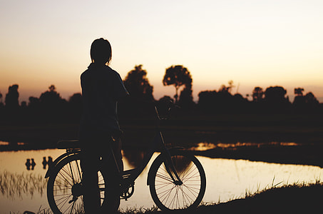 silhouette of person near bicycle and body of water thumbnail