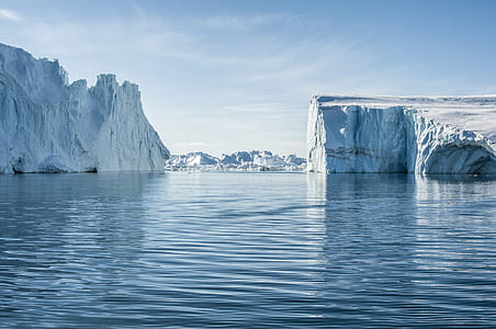 body of water near white mountains under blue sky at daytime thumbnail
