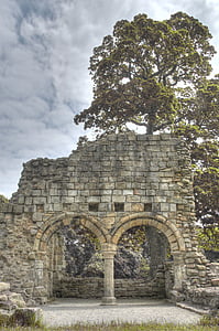 gray brick wall beside green trees thumbnail