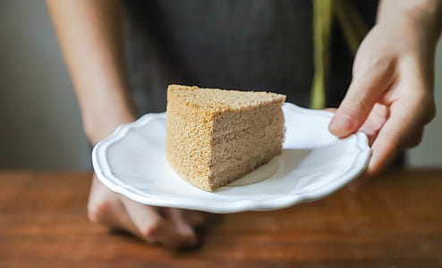 Person Holding Plate Of Sliced Cake thumbnail
