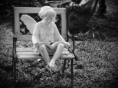 grayscale photography of fairy statue sitting on bench thumbnail