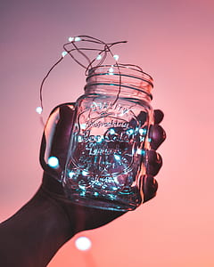 person holding clear glass mason jar with string light thumbnail