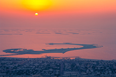 aerial photo of city near body of water during sunset thumbnail