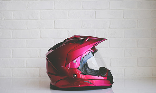 red and black full-face helmet on white floor near white wall thumbnail