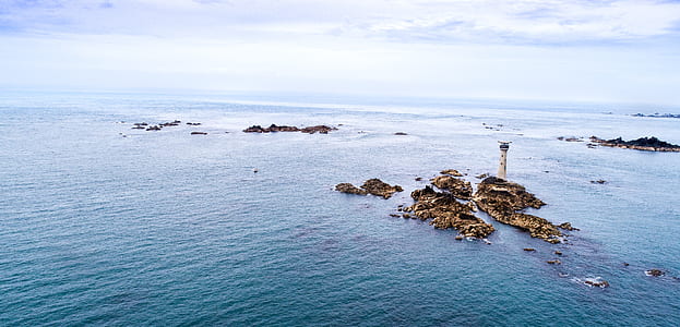 bird's-eye photography of rocks on body of water thumbnail
