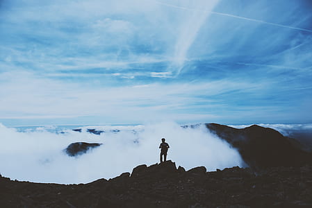 man standing on the cliff near ocean waves thumbnail
