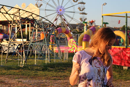 woman standing while holding candy during daytime thumbnail