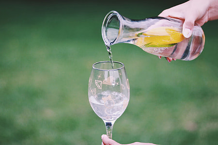 shallow focus photography person filling wine glasses of water thumbnail