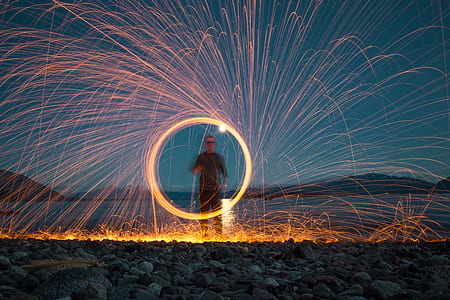 steel-wool photography of man standing on plain field thumbnail